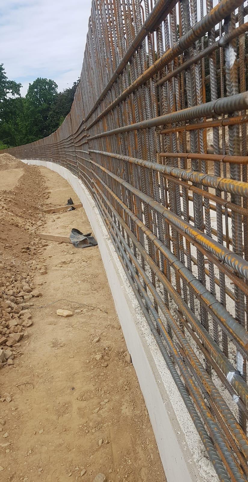 Long retaining wall reinforced with horizontal and vertical rebar